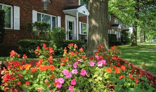 a garden of flowers in front of a house